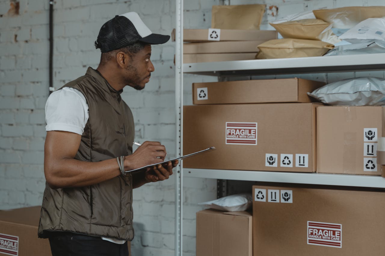 services-02 Courier checking packages in a warehouse, ensuring fragile handling